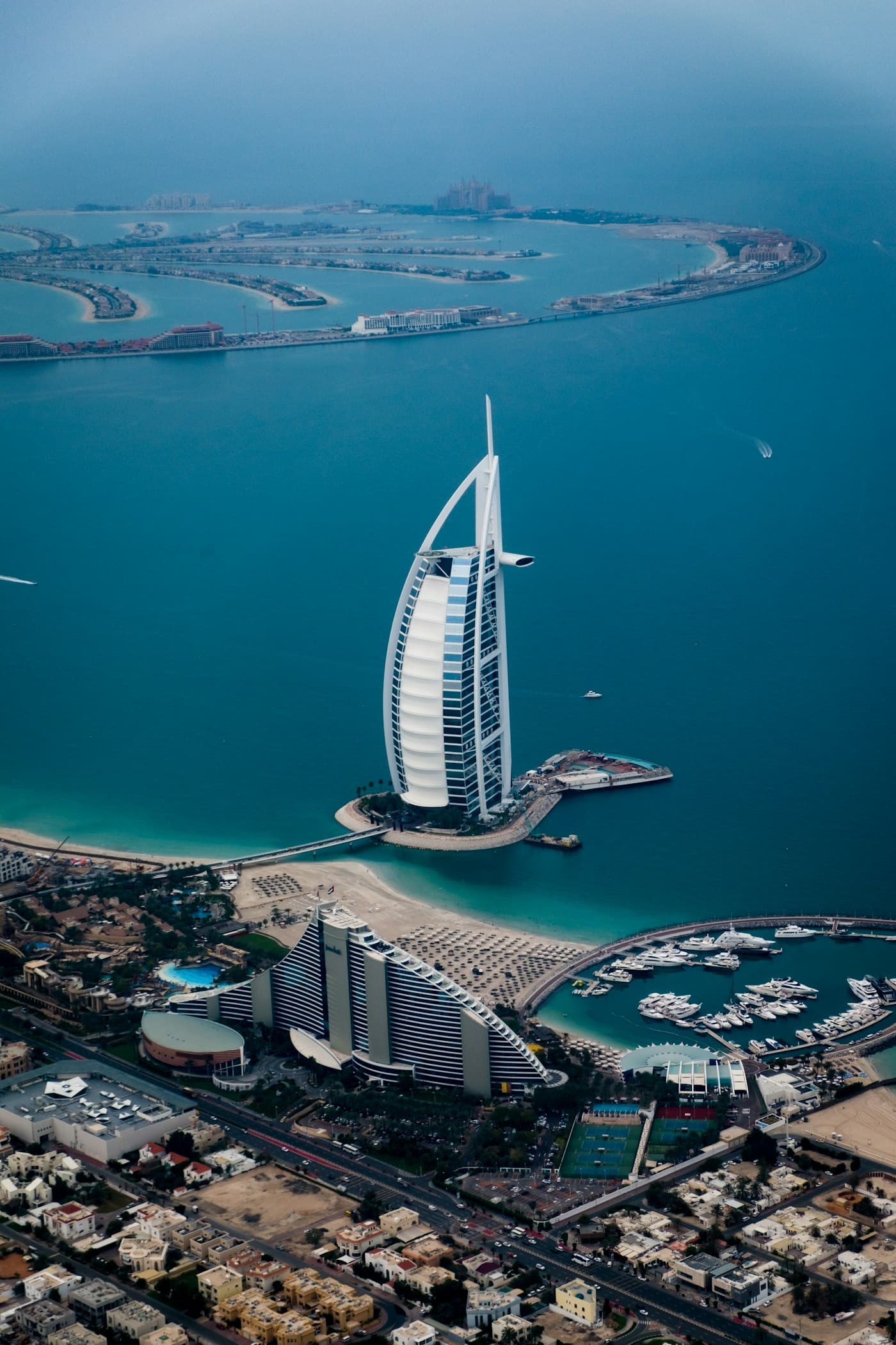 Aerial view of the Burj Al Arab with Palm Jumeirah behind it